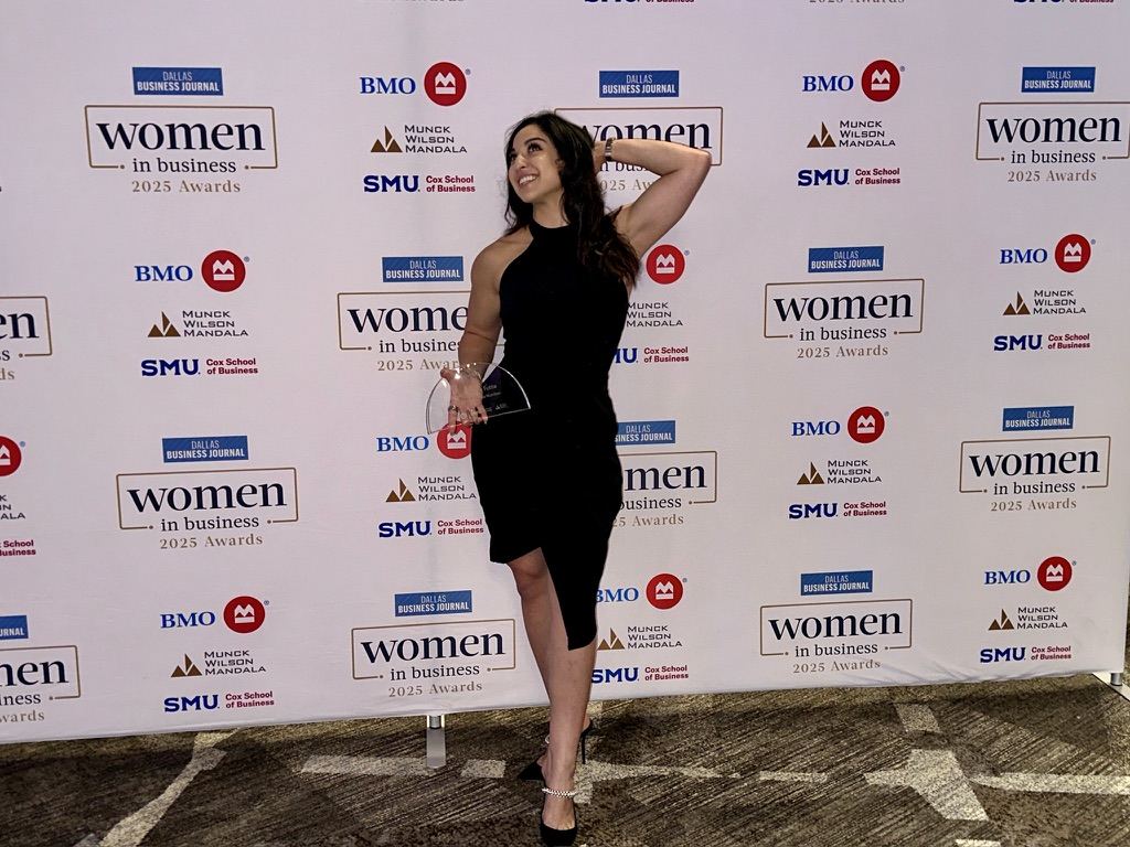 Alexia Tuttle holding her award in front of the Dallas Business Journal Women in Business 2025 Awards backdrop.