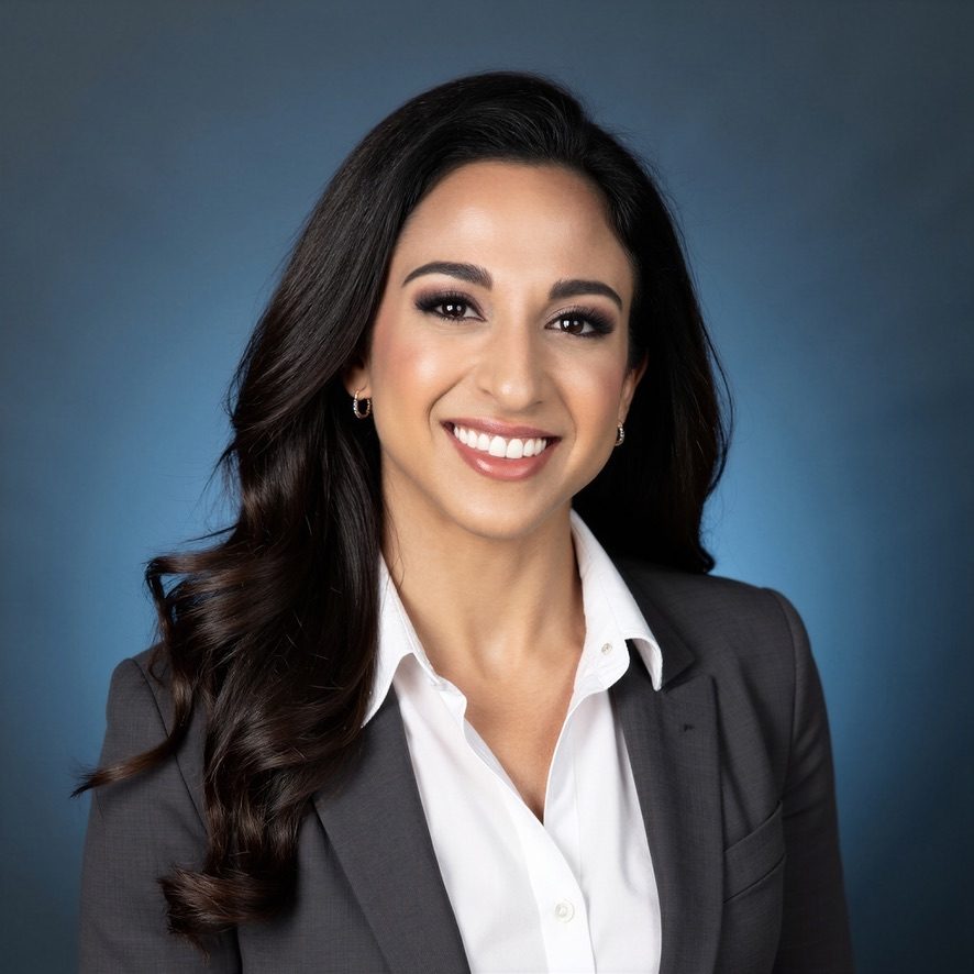 Portrait of Alexia Tuttle in a grey blazer and white shirt.
